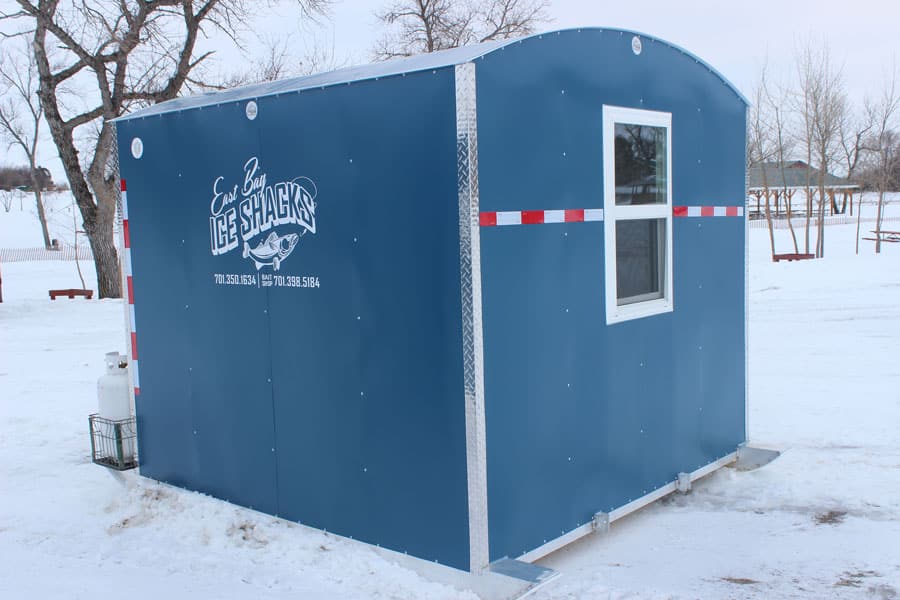 Blue exterior of ice house available to rent with windows and heating elements to keep the house warm.